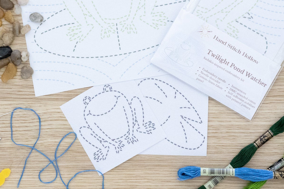 Crafting materials including templates, thread, and needles on a wooden surface